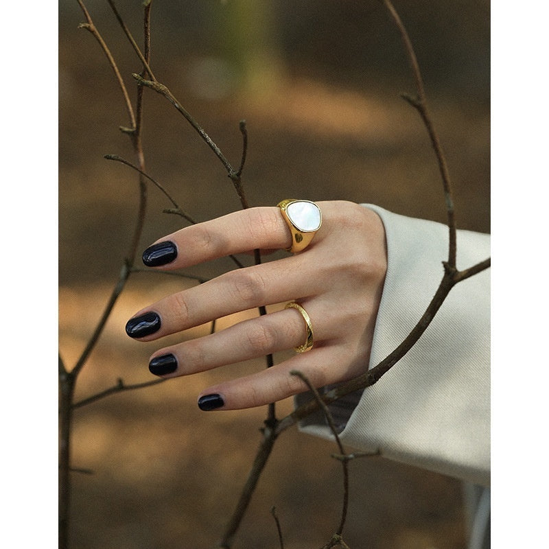 BoxUnboxed gold statement ring with pearlescent inlay on a hand with dark nail polish, 925 sterling silver