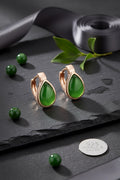 BoxUnboxed rose gold plated huggie earrings featuring natural nephrite jade water droplet stones on a slate background.